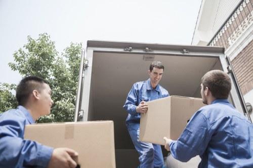 Movers carrying household items through a Balham property